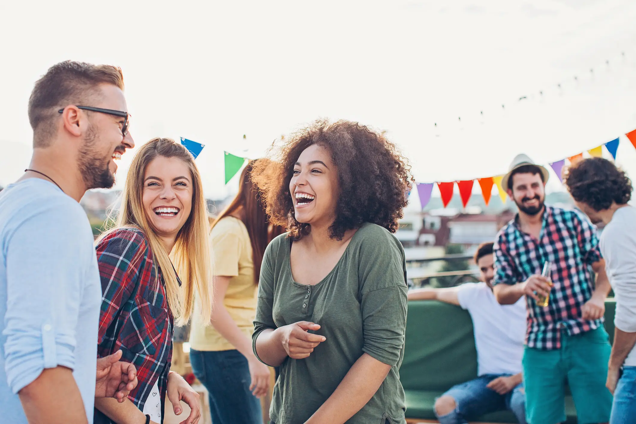 Group of friends laughing at outdoor party.