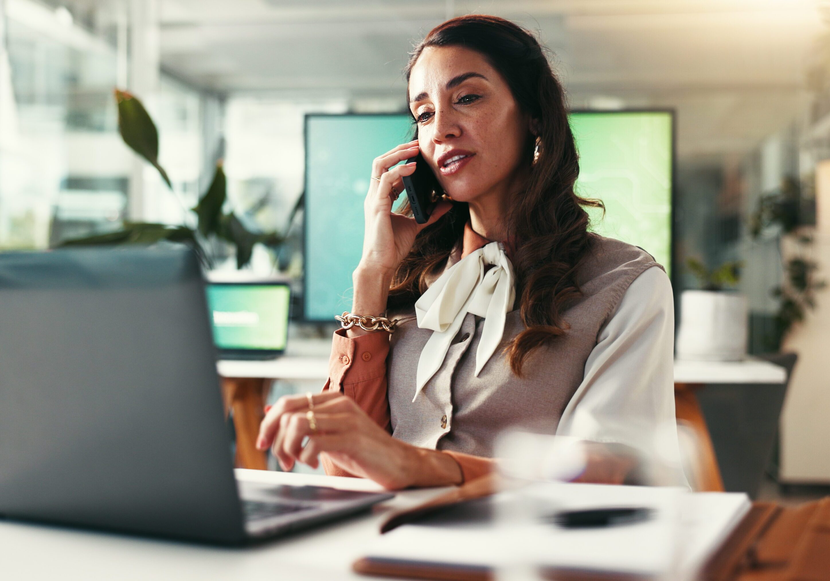Phone call, creative and woman in office, negotiation and conversation with contact for budget and talking. Discussion, event planner and planning for booking of venue with laptop, online and person